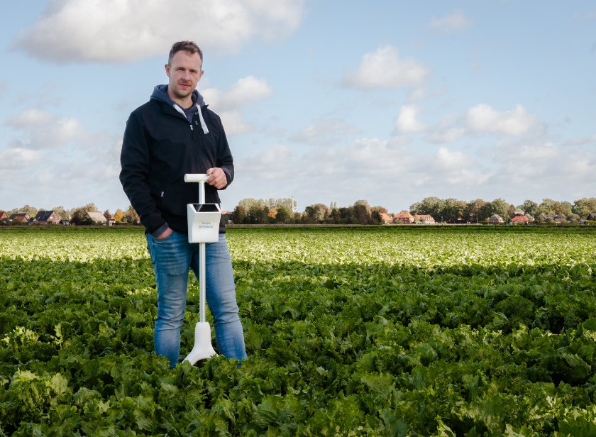 Ein Bild von Jan Uhrbach, der mit dem FarmLab in der Hand auf einem seiner Salatfelder steht