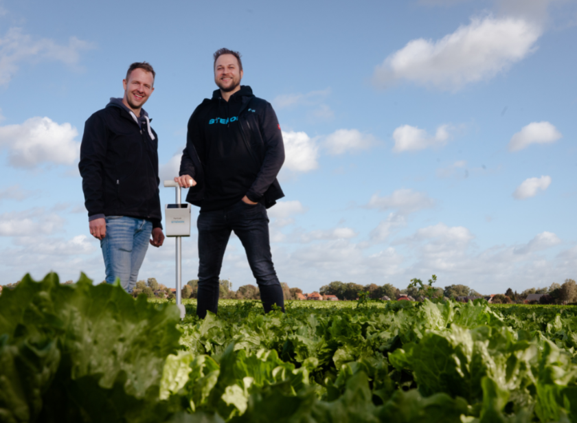 Jan Uhrbach und Niels Grabbert stehen gemeinsam mit dem FarmLab auf einem Feld
